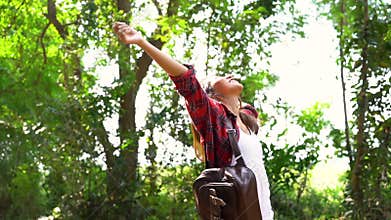 Slow motion - Happy young Asian woman traveler with backpack walking in forest.