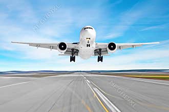 Passenger aircraft with a cast shadow on the asphalt landing on a runway airport, motion blur.