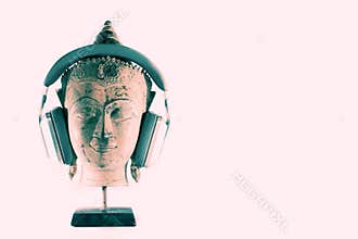 Spiritual music therapy. Buddha head in meditation with modern h