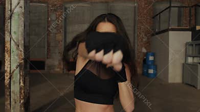 Young woman training portrait punch boxing gloves for punching. Girl making Strong kick. CrossFit. Female boxer woman