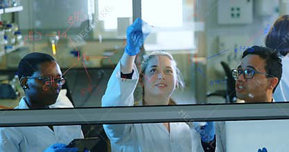 Team of scientists discussing over glass board 4k