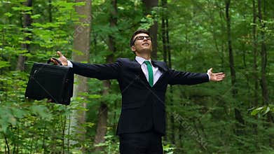 Young man in business suit breathing deep outdoors, abstracting from city stress