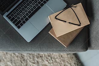 Laptop with glasses and books lying