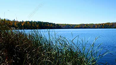 Blue sky with sunshine over beautiful serene remote northern Minnesota lake