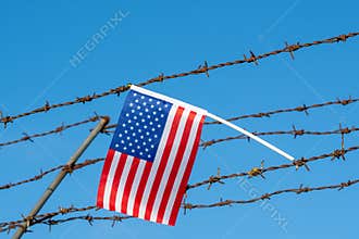 American flag on barbed wire fence