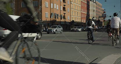 Bicycle commuters crossing an intersection in central Stockholm. Anonymous people shot in slow motion, 4K.
