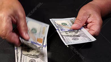 Counting US currency. Old woman counts money. New dollars in hands with wrinkles. Close up view. Business, finance