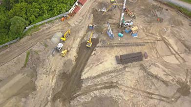 Aerial top view of three tip trucks standing next to each other awaiting loading of sand and soil on a construction site and a cou