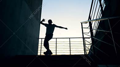Skateboarder silhouette skateboarding in the city.