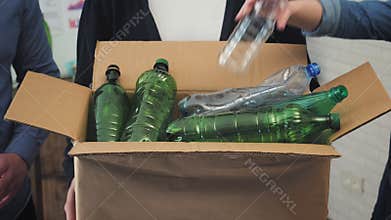 People in office putting plastic garbage in recycling bin