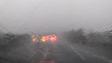Car wipers removing heavy rain from the windshield during ride.