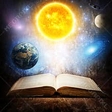 Opened magic book with sun, earth, moon, saturn, stars and galaxy. Concept on the topic of astronomy or fantasy. Elements of this