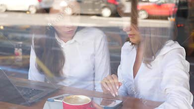 Two businesswomen working in cafe together
