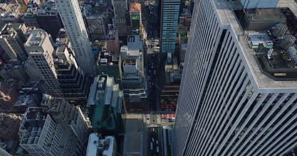 High angle view of traffic in street around GM high rise building. Tilt down on cars passing through intersections
