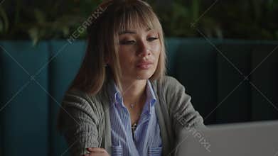 Portrait of a beautiful, young and attractive Asian woman is sitting and looks worried and serious as she broods in