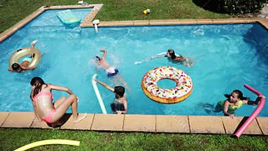 Happy kids have fun swim pool with inflatable toys