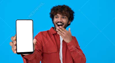 Excited young indian man holding phone showing big white mockup screen.