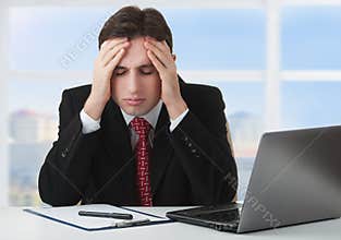 Young businessman under stress, fatigue, headache