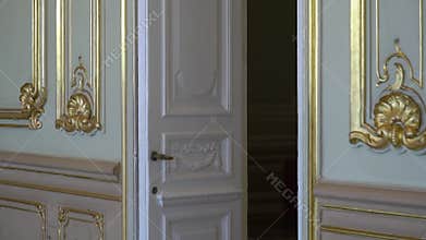 White antique doors in luxurious palace. White walls in historical interior.
