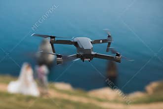 Flying drone shoots wedding video in nature.