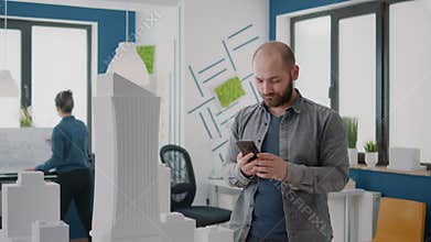 Man contractor using mobile phone to design building model for construction plan and layout