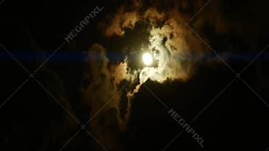 Timelapse of moon over dark dramatic clouds in night sky, anamorphic time lapse