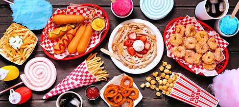 Carnival theme food table scene over a dark wood banner background