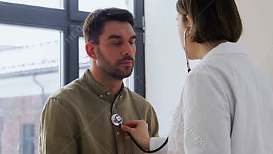 doctor with stethoscope and man at hospital