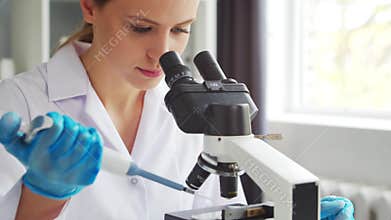 Female doctor works in a modern scientific laboratory using equipment and technologies. The scientist does research and