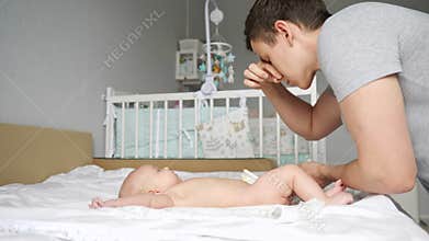 Father changes dirty diaper and holds breath closing nose