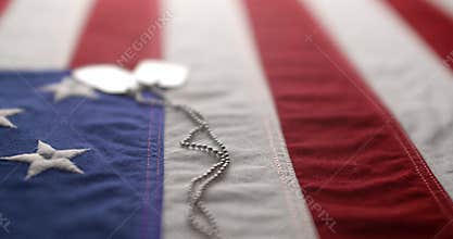 Slow motion of a US American flag with shiny military dog tags. Background for Armed Forces Day, Memorial Day, Veteran`s Day, 4th