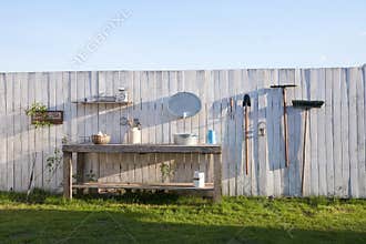 Garden tools on the background of a white fence. The concept of agricultural, garden utensils. Outdoor Gardening tools