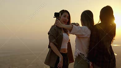 Girl friend group Asians blogger standing and caper enjoying the beauty of nature in the evening sunset and shoot video from their