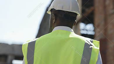 Focused architect looking around at construction site