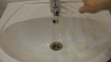 Dirty water flows from the tap into the sink. Contamination of drinking water in the apartment is a problem. Tap water pollution.