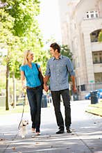 Happy Couple Walking dog down street