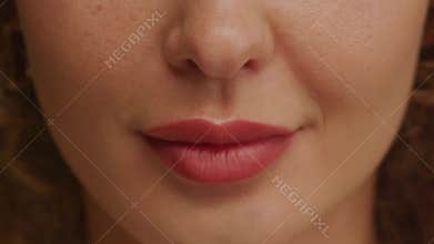 Close up of a charming woman smile with perfect natural teeth and bright lipstick