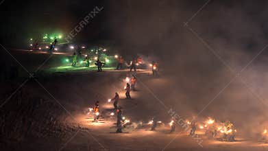 Torchlight descent down ski slope by ski instructors and mountain rescue services to celebrate new year.
