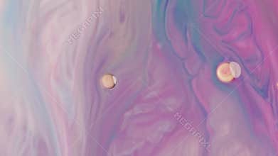 Close-up fluid blue and pink vibrant oil paints blend together