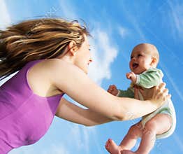 Young Woman Holding Up Baby