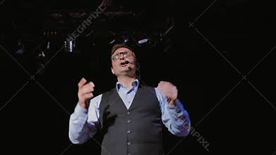 an inspiring speaker from the stage tells how to become successful and productive.