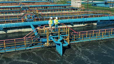 Male specialists talking at a wastewater treatment plant