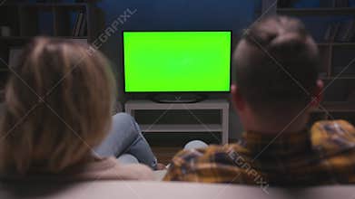 People Couple Watching Green Screen TV Sitting on Couch in Living Room Together