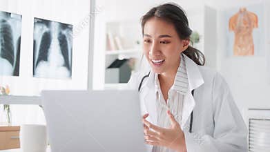 Asian female doctor using laptop computer online video call remote talking to patient