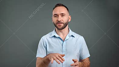 Friendly man influencer explaining talking gesticulating isolated on gray. 4k Dragon RED camera