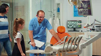 Man nurse inviting kid patient in consultation dental room