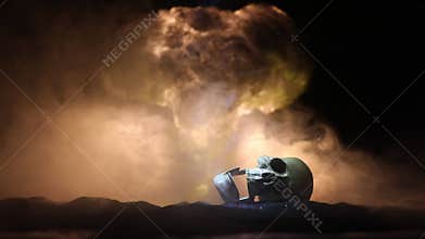 Nuclear war concept. Explosion of nuclear bomb. Creative artwork decoration in dark. Silhouette of soldier standing against giant