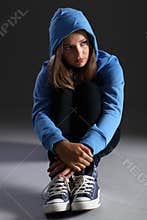 Blonde teenager girl alone and sad in blue hoodie