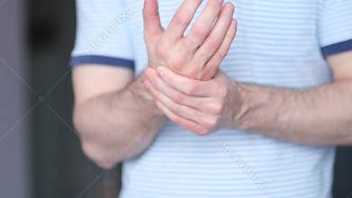 A man massages a joint in his hand. Close up. Carpal tunnel syndrome, arthritis, neurological disease concept. Numbness