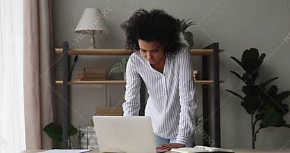 Thoughtful African businesswoman hurrying makes urgent task working on computer